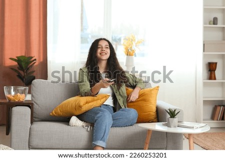 Teenage girl watching TV at home