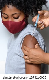   teenage girl wearing a covid-19 protective mask receiving the vaccine in the arm
