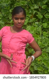 A Teenage Girl Wearing A Pink Frock With Gold Chain, Nose Pin And White Bangles Posing For Camera,  Selective Focusing