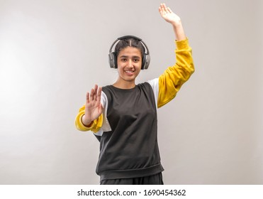 a teenage girl  with wireless headphone while dancing in studio