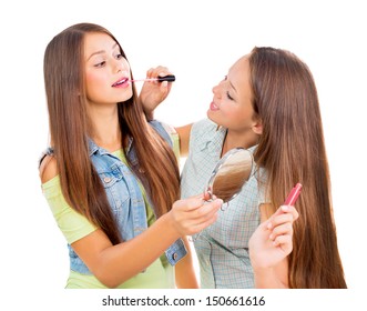 Teenage Girls Applying Make up and Looking in the Mirror. Pretty Teens Having Fun and Putting Makeup Lipstick or Lip gloss. Joyful Teenagers Isolated on a White Background. Cosmetics - Powered by Shutterstock