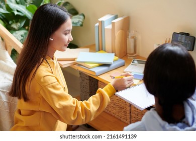 Teenage Girls Attending Online Math Class, Listening To Teacher And Writing In Notebooks