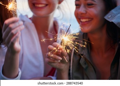 Teenage girls celebrate and smile with sparklers close up shot - Powered by Shutterstock