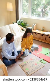 Teenage Girls Decorating Placard They Made For Climate Change Awareness Campaign