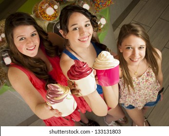 Teenage Girls Eating Frozen Soft Serve Yogurt.