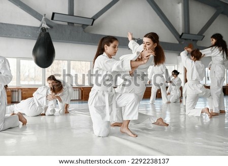Teenage girls fighting at aikido training in martial arts school
