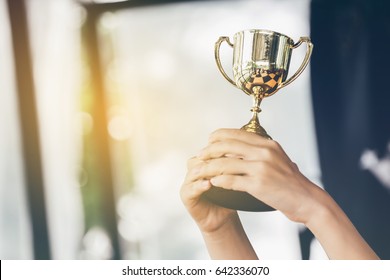 Teenage girls' hands are holding trophies, congratulations on success.Conception of victory in the competition.Focus on the trophy - Shutterstock ID 642336070