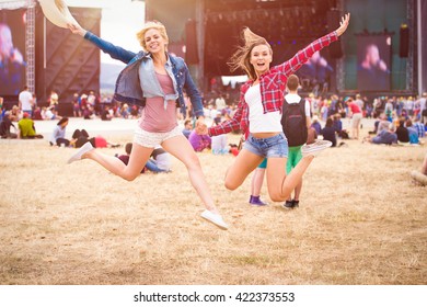 Teenage girls, music festival, jumping, in front of stage - Powered by Shutterstock