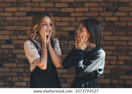 teenage girls on a brick wall background