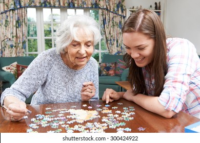 Teenage Granddaughter Helping Grandmother With Jigsaw Puzzle - Powered by Shutterstock