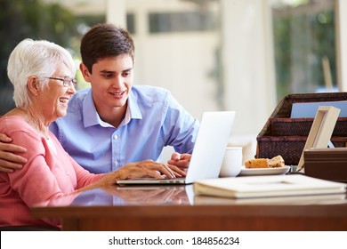 Teenage Grandson Helping Grandmother With Laptop