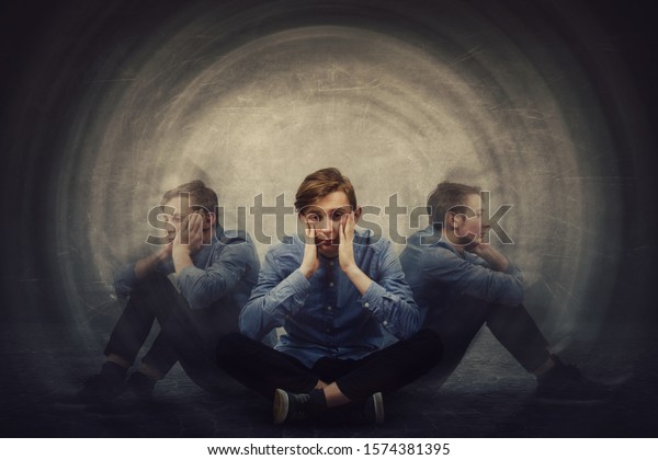 Teenage guy seated on the floor suffer split\
emotions into three different inner personalities. Multipolar\
mental health disorder. Schizophrenia psychiatric disease. Dementia\
reactions mood change.