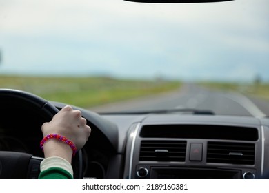 A Teenage Hand Drives A Steering Wheel On A Summer Vacation After Getting A Learners Permit After A Driving Safety Course.