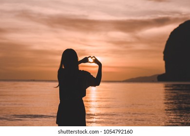 A Teenage Hand Made Heart On The Beach At Sunset.