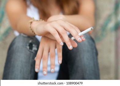 Teenage Hands Holding Cigarette.