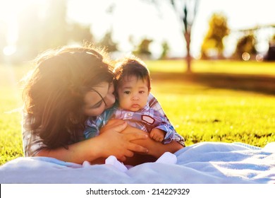 Teenage mother spending time with her 3 month old son at the park -- image taken at a park in Reno, Nevada