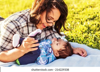 Teenage mother spending time with her 3 month old son at the park -- image taken at a park in Reno, Nevada
