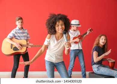 Teenage musicians playing against color wall