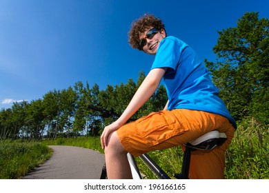 Teenage Riding Bike In City Park