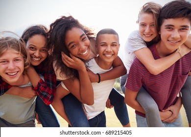 Teenage school friends having fun piggybacking outdoors - Shutterstock ID 689215405