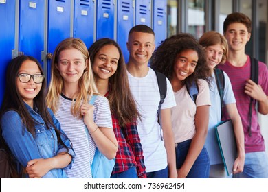 Teenage school kids smiling to camera in school corridor - Shutterstock ID 736962454
