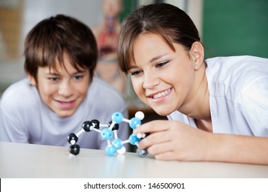 Teenage schoolchildren examining molecular structure at desk in lab - Powered by Shutterstock