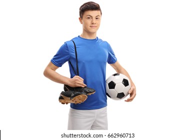 Teenage soccer player with a football and a pair of soccer shoes isolated on white background