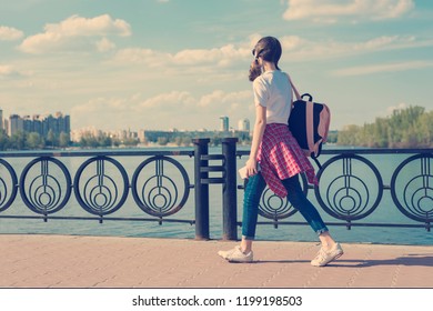 Teenage student girl walking down the street with backpack. Back to school, copy space.
