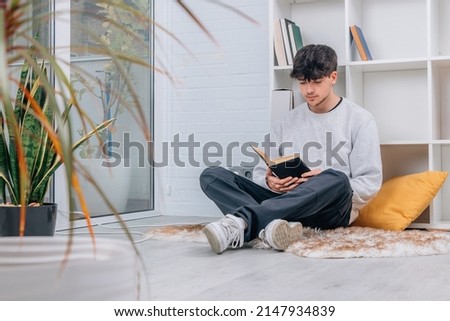teenage student at home or library reading a book or studying