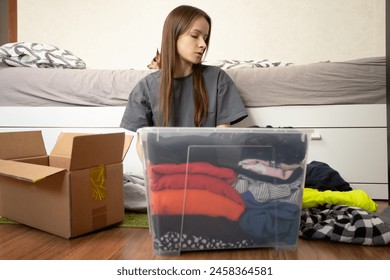 Teenage student packing things to move, wrapping fragile items in bubble wrap, bed and room preparation, university relocation. - Powered by Shutterstock