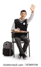 Teenage Student Seated In A School Chair Holding His Hand Up Isolated On White Background