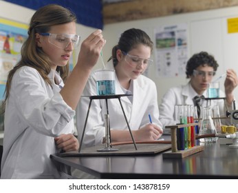 Teenage students caring out experiments in chemistry class
