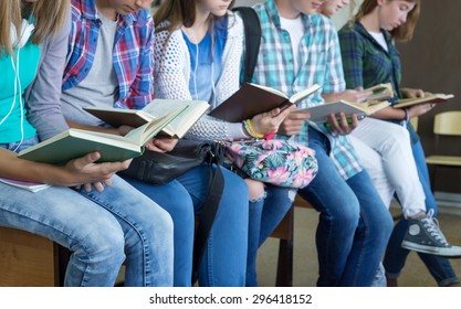 Teenage Students In Library Reading Books