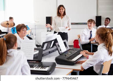 Teenage Students Studying Electronic Keyboard In Music Class