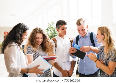 Teenage Students Walking In High School Hall, Talking.