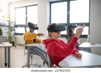 Teenage students wearing virtual reality goggles at school in computer science class - Powered by Shutterstock