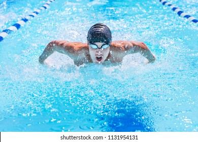 Teenage swimmer swimming butterfly stroke in a race