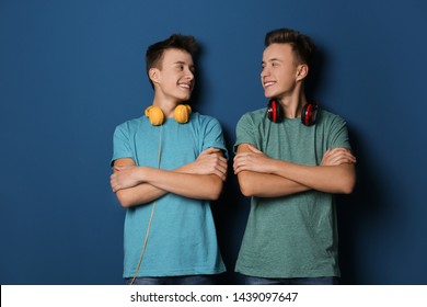 Teenage twin brothers with headphones on color background - Shutterstock ID 1439097647