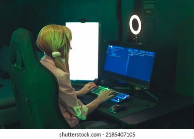 Teenage White Girl Wearing Cute Ponytails Sitting In Gaming Chair Using Professional Computer With Ring Light. Dark Green Lighting. High Quality Photo