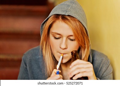 Teenage woman drinking beer and smoking cigarette. - Powered by Shutterstock