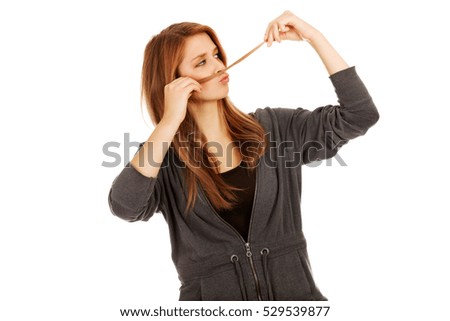 Teenage woman making moustache from hair