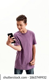 Teenaged disabled boy with cerebral palsy looking happy while holding and using smartphone, posing isolated over white background. Children with disabilities and special needs, Technology concept