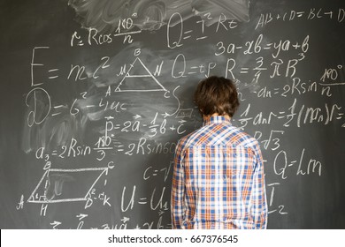 Teenageer Boy having trouble with complicated math formulas on black board