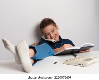 Teenager With Bad Upbringing Talking To The Phone Putting His Feet On The Table