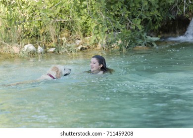 Teenager bathing in a lake with her dog. Place of the taking Castilla la Mancha, Spain. - Powered by Shutterstock