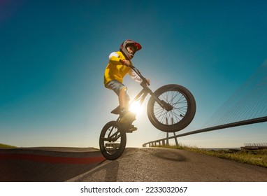 A teenager BMX Racing Rider performs tricks in a skate park on a pump track. - Powered by Shutterstock