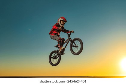 A teenager BMX Racing Rider performs tricks in a skate park on a pump track. - Powered by Shutterstock