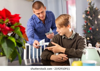 Teenager Boy Asking His Young Father For Pocket Money Before Celebrating Christmas At Home