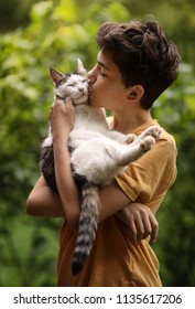 Teenager Boy With Cat Kiss Hug On Green Summer Grass Close Up Photo