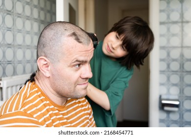 Teenager boy cutting father's hair with electronic shaver in bathroom at home. Happy fatherhood, quarantine haircut. - Shutterstock ID 2168454771